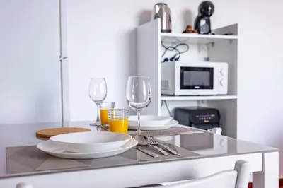 a table with plates and glasses on a kitchen counter at Solar do Pico Studio in Ponta Delgada