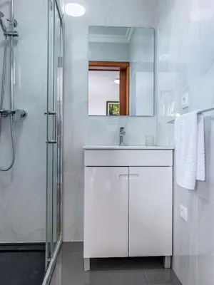 a white bathroom with a sink and a shower at Solar do Pico Studio in Ponta Delgada