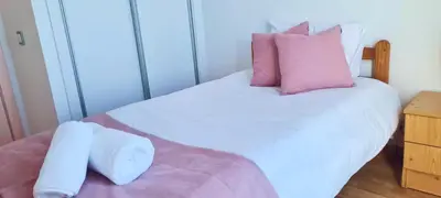 a bedroom with a bed with white sheets and pillows at Skyline Villas RC in Arco da Calheta