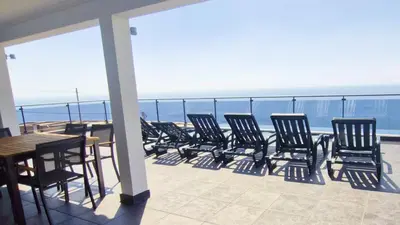 a kitchen with a black table and black chairs at Skyline Villas Top in Arco da Calheta