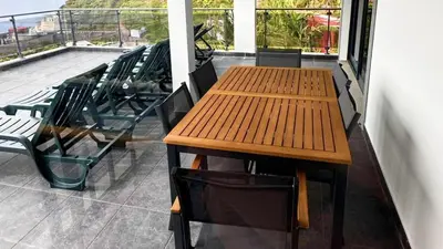 a kitchen with a glass table and red tiles at Skyline Villas Top in Arco da Calheta