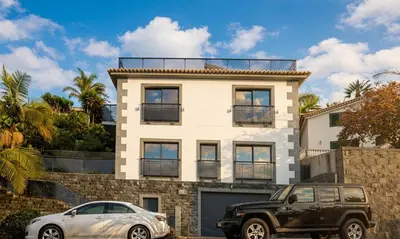 a white house with a red frame around it at Skyline Villas Top in Arco da Calheta