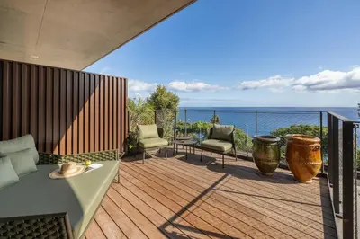 a balcony with a table and chairs and the ocean at Savoy Monumentalis VIII by An Island Apart in Funchal