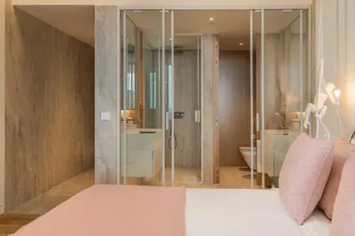 a bedroom with a bed and a bathroom with a shower at Savoy Monumentalis VIII by An Island Apart in Funchal
