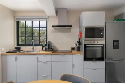 a white kitchen with a sink and a refrigerator at Relax Garden House by An Island Apart in Arco da Calheta