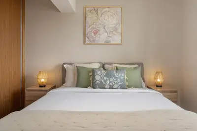 a bedroom with a large white bed with two lamps at Relax Garden House by An Island Apart in Arco da Calheta