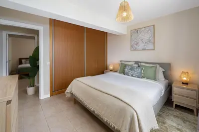 a bedroom with a large white bed with green pillows at Relax Garden House by An Island Apart in Arco da Calheta
