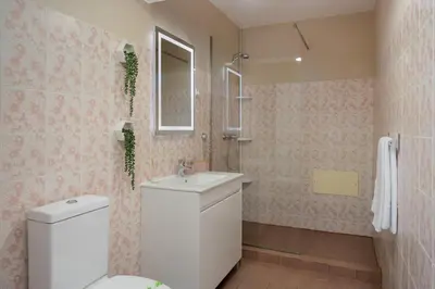a bathroom with a white toilet and a sink at Relax Garden House by An Island Apart in Arco da Calheta