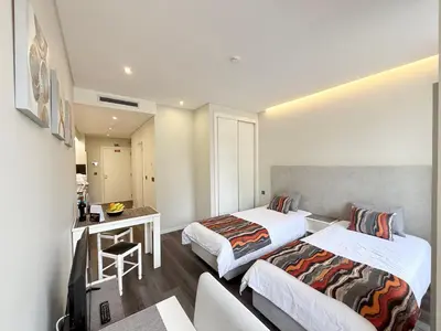 a hotel room with two beds and a desk at Gold Center Funchal 102 in Funchal