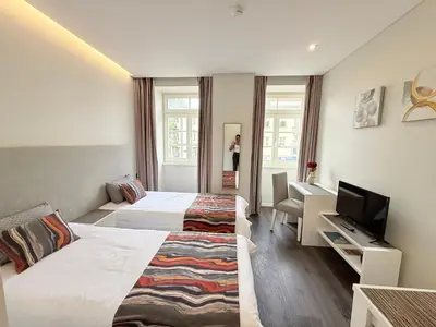 a hotel room with two beds and a television at Gold Center Funchal 102 in Funchal
