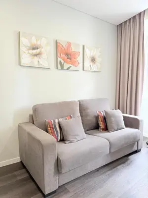 a couch in a living room with three paintings on the wall at Gold Center Funchal 105 in Funchal