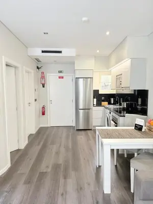 a kitchen with white cabinets and a stainless steel refrigerator at Gold Center Funchal 105 in Funchal