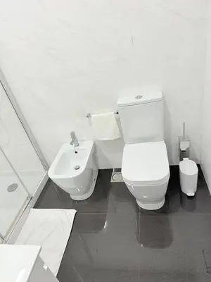 a white bathroom with a toilet and a sink at Gold Center Funchal 105 in Funchal