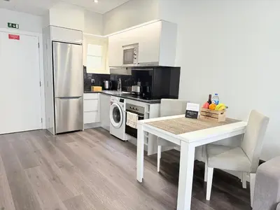 a kitchen with a white table and a refrigerator at Gold Center Funchal 105 in Funchal