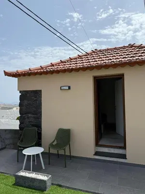 a small house on a street with a wall at Tini´s House Madeira Holiday in Gaula