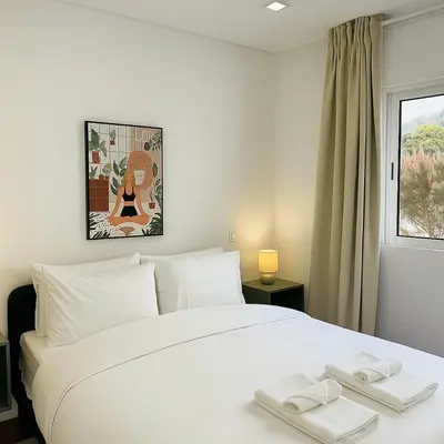 a bedroom with a white bed with two towels on it at Atlantic View in Arco da Calheta