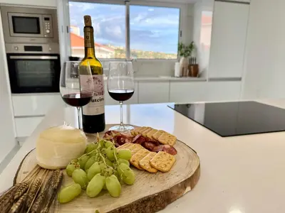 a bottle of wine and a plate of cheese and wine glasses at Atlantic View in Arco da Calheta