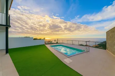 a swimming pool on the balcony of a house at Atlantic View in Arco da Calheta