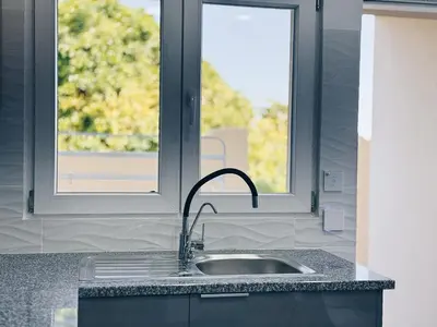 a kitchen with a sink and a window at A Casa Elena - Modern Family home in Praia da Luz in Luz