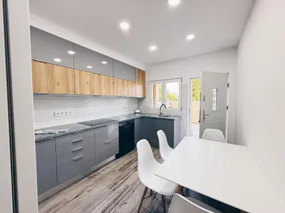 a kitchen with a white table and white chairs at A Casa Elena - Modern Family home in Praia da Luz in Luz