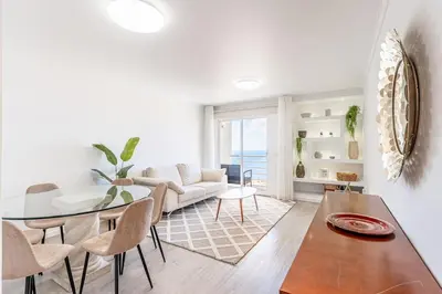 a living room with a table and a couch at Topaz Scape Garajau Madeira by GRM in Caniço