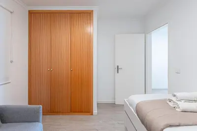 a bedroom with a wooden cabinet next to a bed at Topaz Scape Garajau Madeira by GRM in Caniço