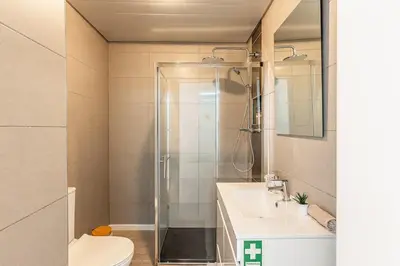 a bathroom with a shower and a toilet and a sink at Topaz Scape Garajau Madeira by GRM in Caniço