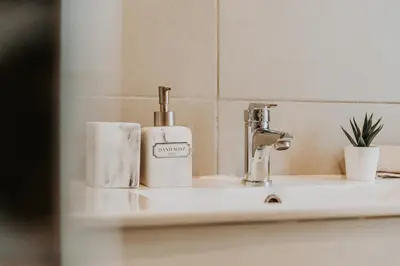 a bathroom sink with a soap dispenser on it at Topaz Scape Garajau Madeira by GRM in Caniço