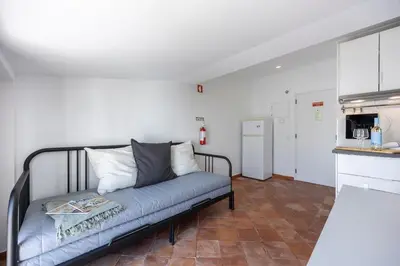 a living room with a couch and a kitchen at Estúdio Praia da Luz in Luz