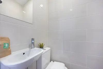 a white bathroom with a sink and a toilet at Estúdio Praia da Luz in Luz