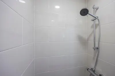 a shower with a shower head in a bathroom at Estúdio Praia da Luz in Luz