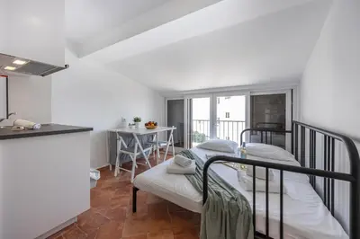 a room with two beds and a kitchen at Estúdio Praia da Luz in Luz