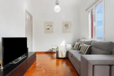 a living room with a couch and a flat screen tv at Casa Da Avó Ferreirinha in Seixal