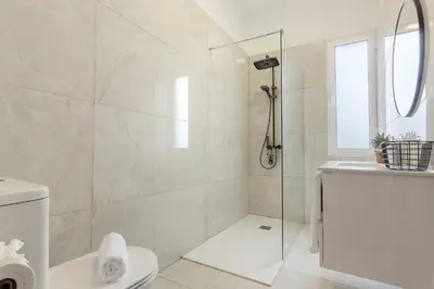 a white bathroom with a shower and a toilet at Casa Da Avó Ferreirinha in Seixal
