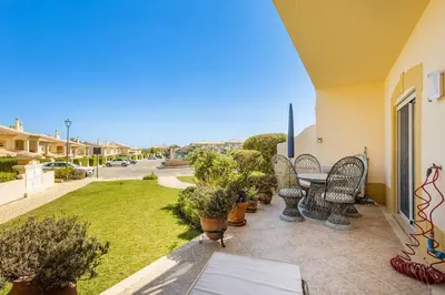 a patio with chairs and a table and a yard at Apartamento em Luxury Golf Resort in Lagos