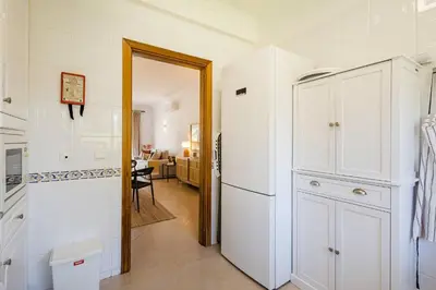 a kitchen with white cabinets and a refrigerator at Apartamento em Luxury Golf Resort in Lagos