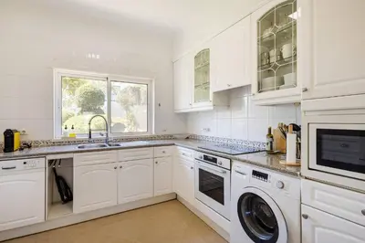 a white kitchen with a sink and a dishwasher at Apartamento em Luxury Golf Resort in Lagos