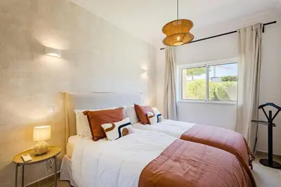 a bedroom with two beds and a window at Apartamento em Luxury Golf Resort in Lagos
