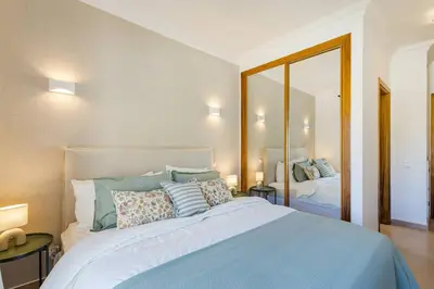 a bedroom with a large bed and a mirror at Apartamento em Luxury Golf Resort in Lagos