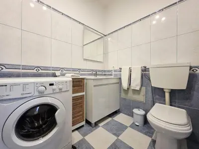 a bathroom with a washing machine and a toilet at Blue Ship Residence in Funchal