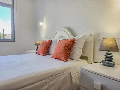 a bedroom with a white bed with red pillows at Blue Ship Residence in Funchal