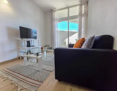a living room with a couch and a tv and a table at Blue Ship Residence in Funchal