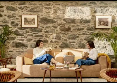 two women sitting on a couch in a living room at Casa da Fajã Alta in São Jorge