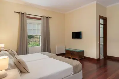 a hotel room with two beds and a window at Casa da Fajã Alta in São Jorge