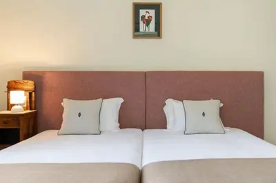 two beds with white pillows in a hotel room at Casa da Fajã Alta in São Jorge