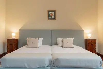 two beds with white sheets and pillows in a room at Casa da Fajã Alta in São Jorge