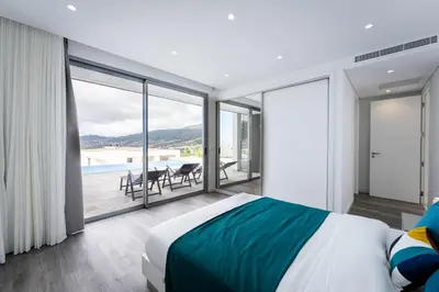 a bedroom with a bed and a view of a pool at Villa Matias - Private pool and family comfort in Arco da Calheta