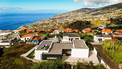 an aerial view of a town with the ocean at Villa Matias - Private pool and family comfort in Arco da Calheta