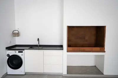 a kitchen with a washing machine and a sink at Villa Matias - Private pool and family comfort in Arco da Calheta