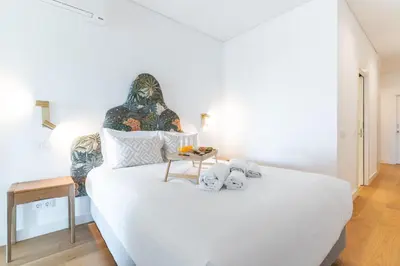 a bedroom with a large white bed with towels on it at Acqua Beach by Atlantic Holiday in Panasqueira